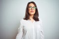 Young beautiful business woman wearing glasses over isolated background with serious expression on face Royalty Free Stock Photo