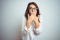 Young beautiful business woman wearing glasses over isolated background shocked covering mouth with hands for mistake Royalty Free Stock Photo