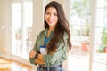 Young beautiful business woman wearing id card and smiling confident with crossed arms