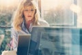 Young beautiful business woman working at laptop computer at sunny office.Panoramic windows on blurred background Royalty Free Stock Photo