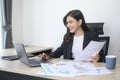 Young beautiful business woman working on laptop with documents in modern office Royalty Free Stock Photo