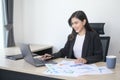 Young beautiful business woman working on laptop with documents in modern office Royalty Free Stock Photo