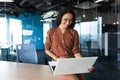 Young beautiful business woman working with laptop smiling and happy, Hispanic woman inside modern office building Royalty Free Stock Photo