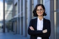 Young beautiful businesswoman in business suit smiling and looking at camera, portrait of successful woman outside Royalty Free Stock Photo