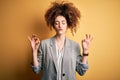 Young beautiful businesswoman with curly hair and piercing wearing elegant jacket relax and smiling with eyes closed doing Royalty Free Stock Photo