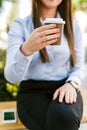 Young beautiful businesswoman drinks coffee to go