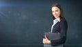 Young beautiful businesswoman portrait with gray briefcase, dark background Royalty Free Stock Photo