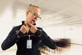 Young beautiful businesswoman screaming with anger in office, prisoner of job in cuffs