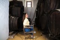 Young beautiful businesswoman sitting on a chair in her wine cellar. The woman is making different expressions and gestures Royalty Free Stock Photo