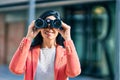 Young beautiful businesswoman smiling happy looking for new opportunities using binoculars at the city Royalty Free Stock Photo