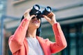 Young beautiful businesswoman smiling happy looking for new opportunities using binoculars at the city Royalty Free Stock Photo