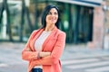 Young beautiful businesswoman smiling happy standing at the city