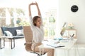 Young beautiful businesswoman stretching in office.