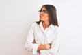 Young beautiful businesswoman wearing glasses standing over isolated white background looking to the side with arms crossed Royalty Free Stock Photo