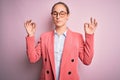 Young beautiful businesswoman wearing jacket and glasses over isolated pink background relax and smiling with eyes closed doing Royalty Free Stock Photo