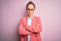 Young beautiful businesswoman wearing jacket and glasses over isolated pink background skeptic and nervous, disapproving Royalty Free Stock Photo