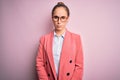 Young beautiful businesswoman wearing jacket and glasses over isolated pink background skeptic and nervous, frowning upset because Royalty Free Stock Photo