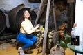 Young and beautiful businesswoman working in her winery taking a bunch of grapes from a basket in which they are being weighed