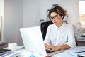 Young beautiful businesswoman working with laptop at workplace in office. Royalty Free Stock Photo