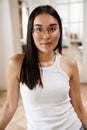 Young beautiful calm asian woman in glasses looking at camera