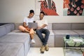 Young beautiful casual African American couple happily watching movie on laptop at home Royalty Free Stock Photo