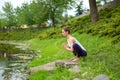 Young beautiful caucasian brunette girl doing yoga on a green lawn against the background of the river Royalty Free Stock Photo