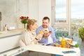 Young beautiful happy couple having breakfast together in kitchen at home. Lifestyle Royalty Free Stock Photo