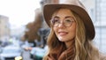 Young beautiful caucasian girl standing outdoors close-up millennial woman with hat and glasses on city background Royalty Free Stock Photo