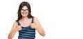 Young beautiful caucasian girl wearing casual clothes and glasses success sign doing positive gesture with hand, thumbs up smiling Royalty Free Stock Photo