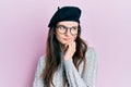 Young beautiful caucasian girl wearing french look with beret thinking concentrated about doubt with finger on chin and looking up Royalty Free Stock Photo