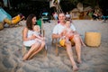 Young beautiful Caucasian happy family of four sitting together embracing at beach cafe in evening sunset. Theme family vacation Royalty Free Stock Photo