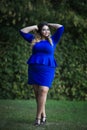 Young beautiful caucasian plus size fashion model in blue dress outdoors, xxl woman on nature Royalty Free Stock Photo