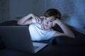 Young beautiful internet addicted sleepless and tired woman working on laptop in bed late at night Royalty Free Stock Photo