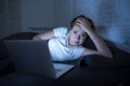 Young beautiful internet addicted sleepless and tired woman working on laptop in bed late at night Royalty Free Stock Photo