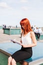 Young redhead business woman in formal outside