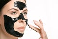 Young beautiful woman applying a mask for the face of the therapeutic black mud. Spa treatment Royalty Free Stock Photo