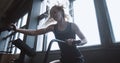 Young beautiful Caucasian woman athlete doing cardio training on stationary gym bike machine with fan wind slow motion. Royalty Free Stock Photo