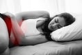 Young beautiful Caucasian woman on bed having stomach pain / period menstruation / food poisoning / cramps sickness Royalty Free Stock Photo