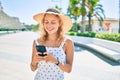 Young beautiful caucasian woman with blond hair smiling happy outdoors using smartphone Royalty Free Stock Photo