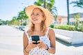 Young beautiful caucasian woman with blond hair smiling happy outdoors using smartphone Royalty Free Stock Photo