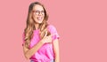 Young beautiful caucasian woman with blond hair wearing casual clothes and glasses cheerful with a smile of face pointing with Royalty Free Stock Photo