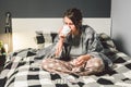 Young beautiful Caucasian woman has a cold, flu with high fever and heat at home in bed. The girl takes headache pills with a Royalty Free Stock Photo