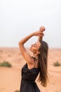 Young beautiful Caucasian woman posing in a traditional Emirati dress abaya in Empty Quarter desert landscape Royalty Free Stock Photo