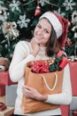 Young and beautiful caucasian woman holding bag of gift boxes lo