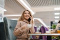 Young beautiful Caucasian woman is talking on a mobile phone, laughing, chatting. Cheerful hipster girl with curly hair using a Royalty Free Stock Photo