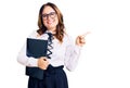 Young beautiful caucasian woman wearing business shirt and glasses holding folder smiling happy pointing with hand and finger to Royalty Free Stock Photo