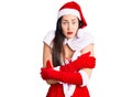 Young beautiful caucasian woman wearing santa claus costume shaking and freezing for winter cold with sad and shock expression on Royalty Free Stock Photo