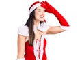 Young beautiful caucasian woman wearing santa claus costume very happy and smiling looking far away with hand over head Royalty Free Stock Photo