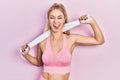 Young beautiful caucasian woman wearing sportswear and towel sticking tongue out happy with funny expression Royalty Free Stock Photo
