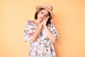 Young beautiful caucasian woman wearing summer dress and hat sleeping tired dreaming and posing with hands together while smiling Royalty Free Stock Photo